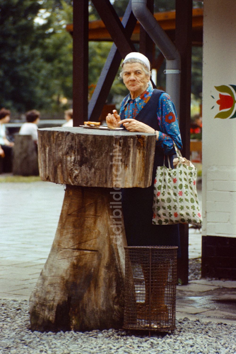 Berlin: Alte Frau isst eine Currywurst in Berlin in der DDR