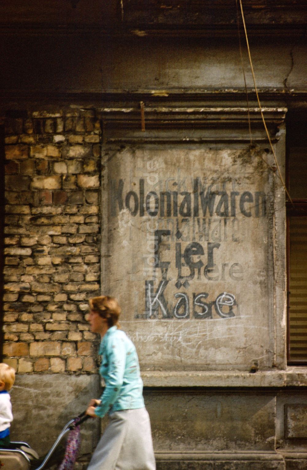 DDR-Fotoarchiv: Berlin - Begriffe Kolonialwaren, Eier, Biere und Käse an einer Hauswand in Berlin in der DDR