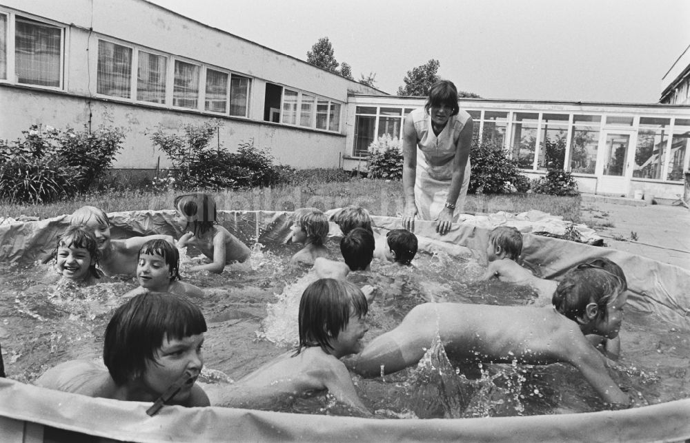 Berlin: Betreuung einer Kindergartengruppe beim Planschen in einem Wasser- Bassin in Berlin in der DDR