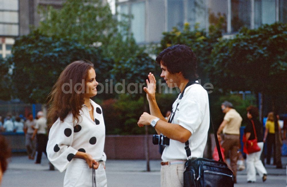 Berlin: Fotograf im Gespräch mit einer Frau in Berlin in der DDR