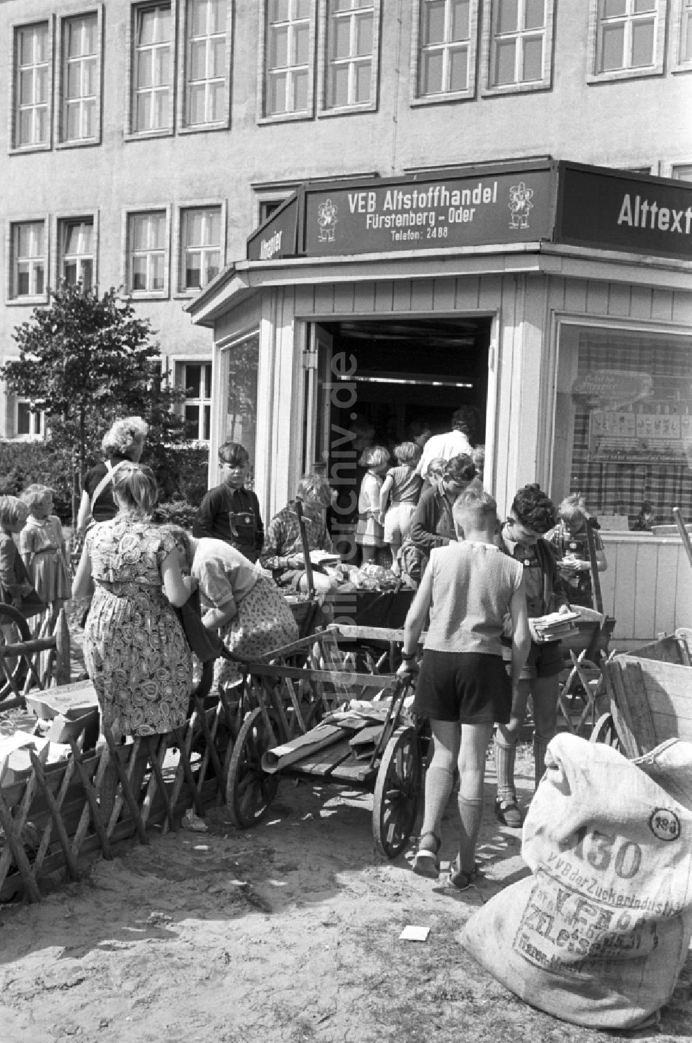 Eisenhüttenstadt (Stalinstadt): Kinder bei der Abgabe gesammelter Altstoffe an einer Annahmestelle des VEB Altstoffhandel in Fürstenberg-Oder (heute Eisenhüttenstadt) in der DDR