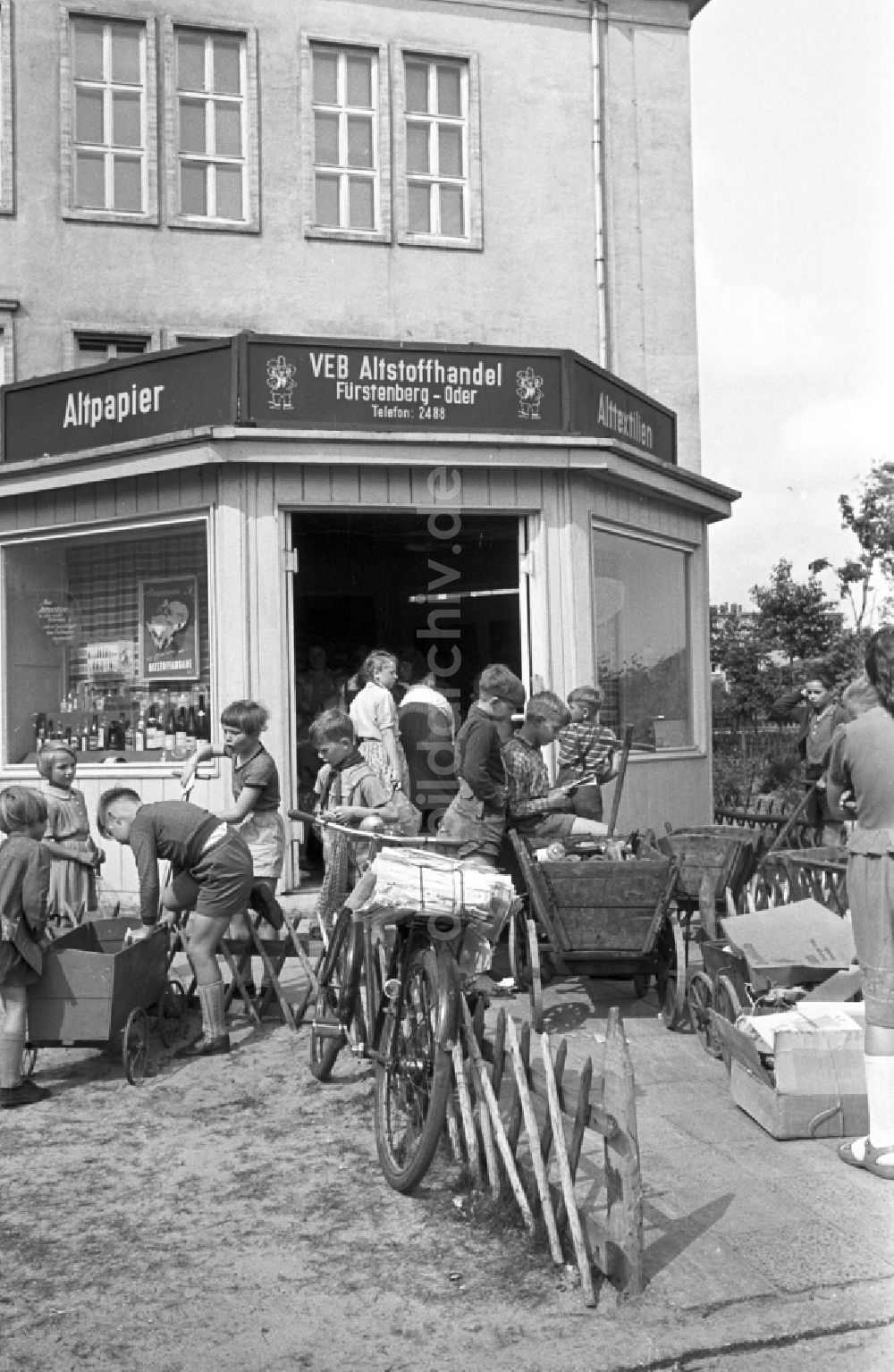 Eisenhüttenstadt (Stalinstadt): Kinder bei der Abgabe gesammelter Altstoffe an einer Annahmestelle des VEB Altstoffhandel in Fürstenberg-Oder (heute Eisenhüttenstadt) in der DDR