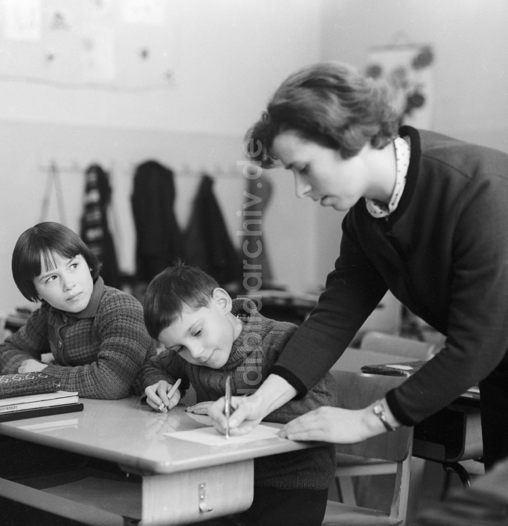 DDR-Fotoarchiv: Berlin - Lehrerin korrigiert Hausaufgaben der Schüler im Klassenraum in Berlin
