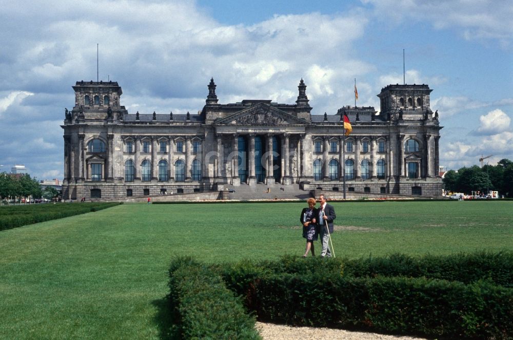 DDR-Fotoarchiv: Berlin - Tiergarten - Reichstag vom Platz der Republik aus gesehen mit der wehenden Fahne der Einheit in Berlin - Mitte