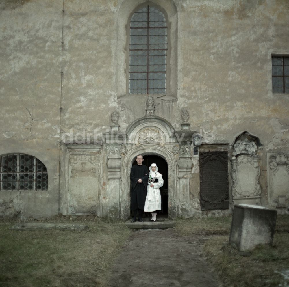 DDR-Bildarchiv: Kreba-Neudorf - Szenenbild Kontinent Hoffnung mit Majka Kowarjec und Alfred Lübke am Eingang einer Kirche in Kreba-Neudorf in der DDR