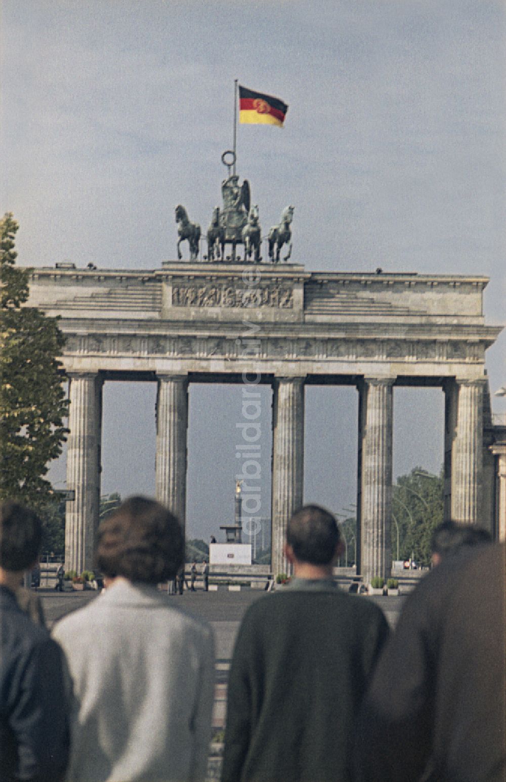 Berlin: Wahrzeichen Brandenburger Tor mit Quadriga und DDR- Fahne in Berlin in der DDR